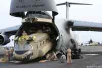 Lockheed C5-Galaxy - Lockheed C5-Galaxy rahtilentokone on USA:n ilmavoimien suurin rahtilentokone ja yksi maailman suurimmista sotalentokoneista. Kuvassa koneesta puretaan raskasta Chinook-kuljetushelikopteria ulos lentokoneesta. Lentokone on suunniteltu kuljettamaan suurikokoista rahtia sekä taisteluvalmiita sotayksiköitä sekä kalustoa mannertenvälisesti, mukaanlukien esimerkiksi M1 Abrams panssarivaunuja.