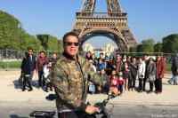 I need your boots, your selfie stick and your bicycle - Tourists trying to take a picture at Eiffel Tower get photobombed by a cyclist